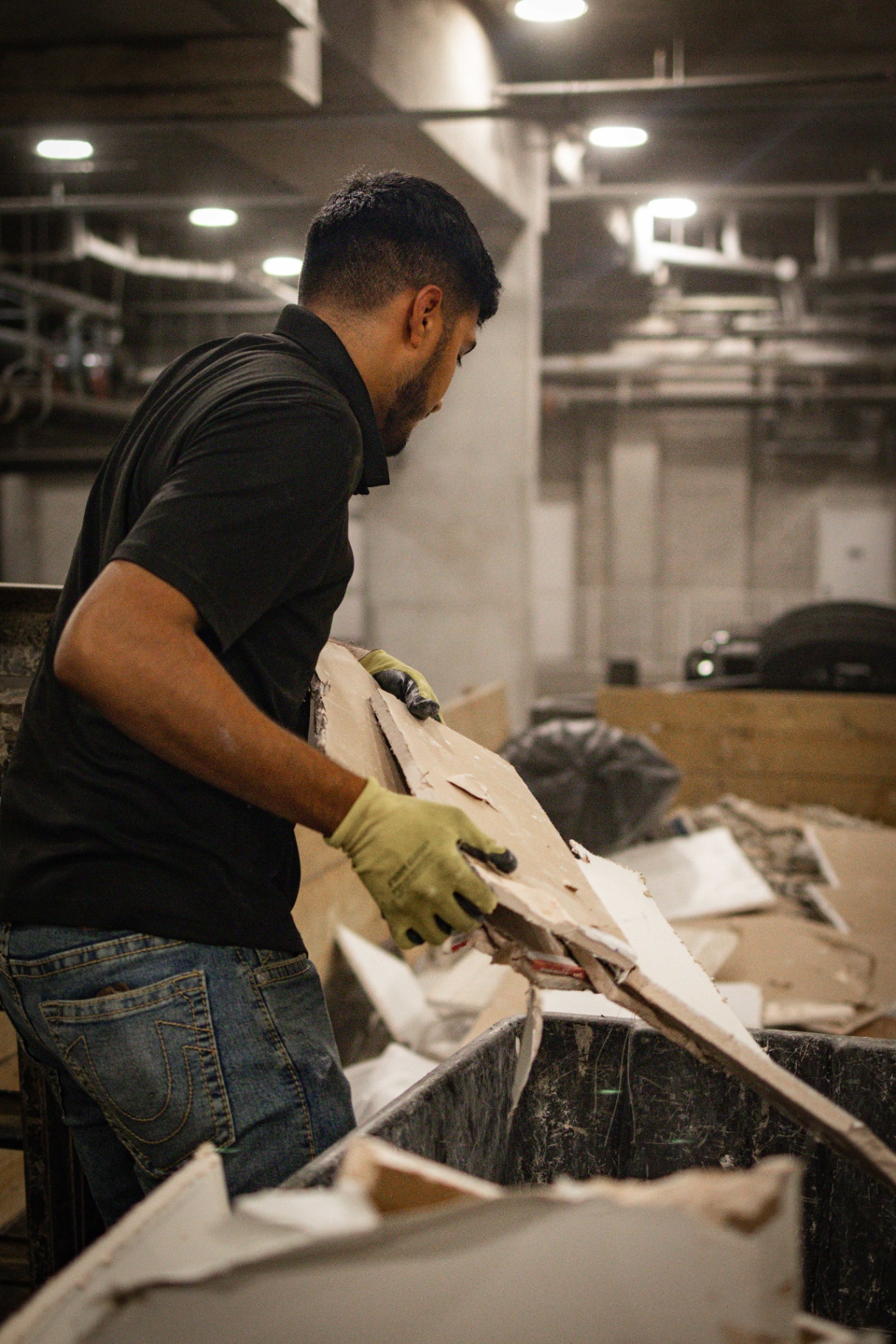 Crew member hauling drywall during a commercial cleanout