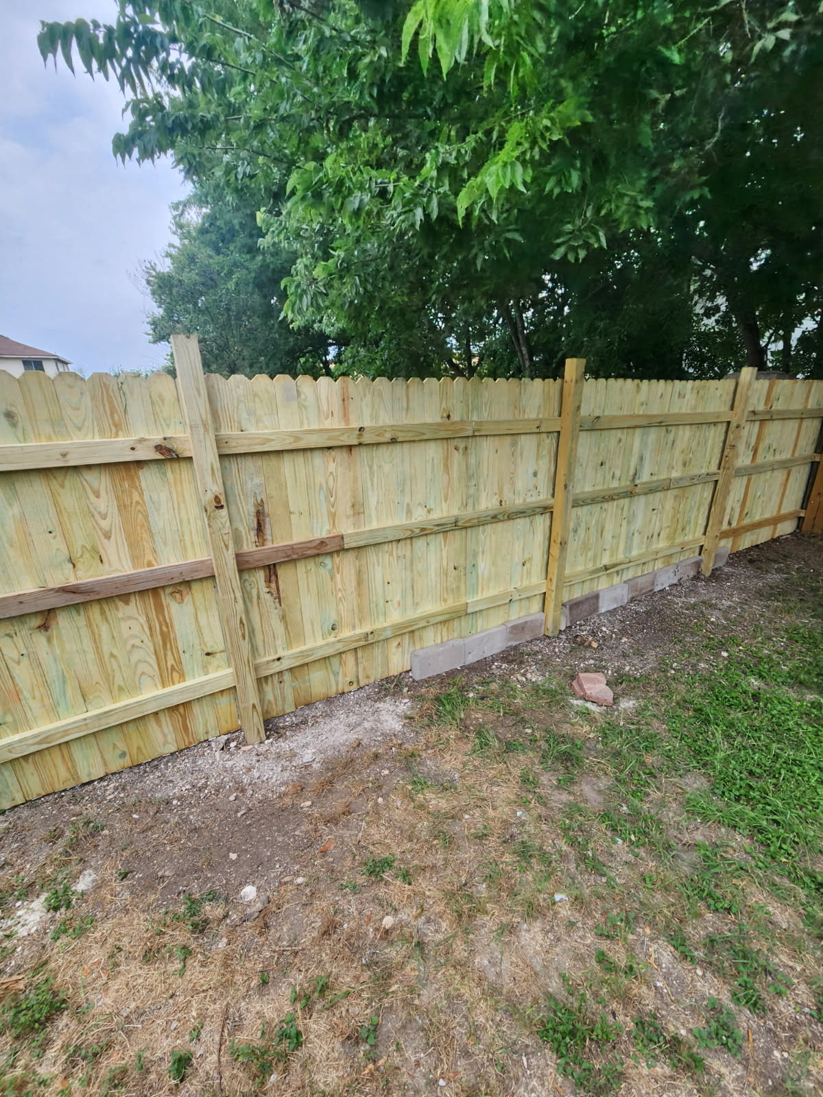 Freshly built stockade-style wood fence by the Green River crew